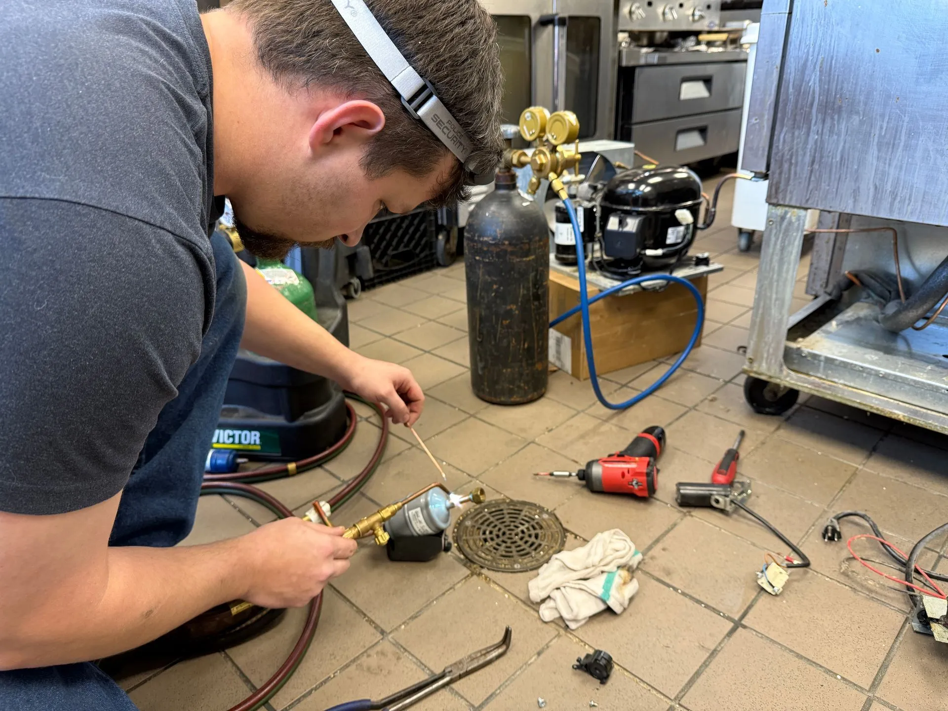 Technician performing a sealed system refrigeration repair
